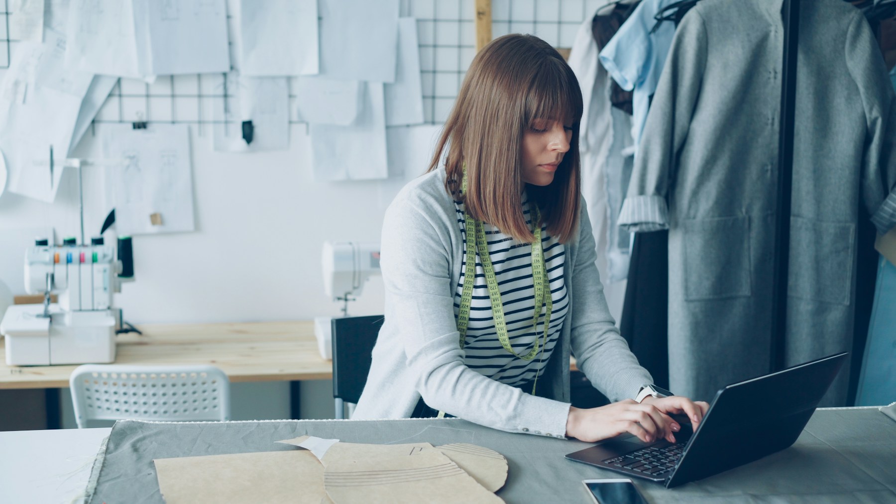 Small business owner working on a laptop in a creative workshop